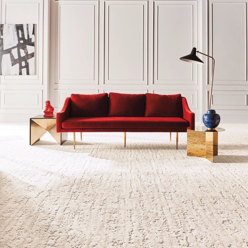 Bright living room with a red velvet couch and beige textured carpet from Carneys Carpet Gallery in Jeffersontown, KY